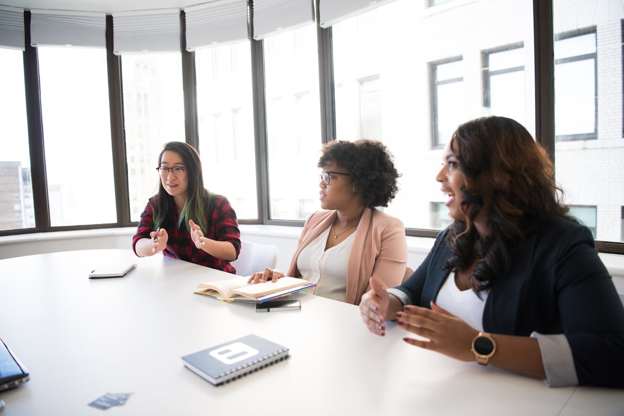 services-02 Three businesswomen engaging in a productive meeting inside a modern office space.